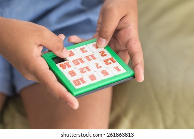 Close Up Hand Of Children Playing Number Slider Puzzle