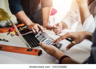 Close up hand of civil engineer or architect business useing calculator about calculate the cost with  for working building plan design project in office. 
