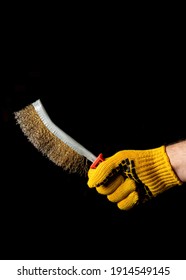 Close Up Hand Of Craftsman In A Glove Holds Brush For Removing Rust
