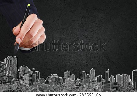 Close up of hand drawing urban city buildings
