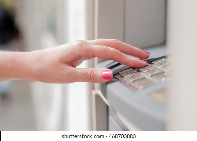 Close Up Of Hand Entering Pin At An ATM. Finger About To Press A Pin Code On A Pad. Security Code On An Automated Teller Machine. Female Arms, ATM - Entering Pin