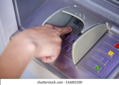 Close Up Of Hand Entering Pin At An ATM. Finger About To Press A Pin Code On A Pad. Security Code On An Automated Teller Machine. Female Arms, ATM - Entering Pin