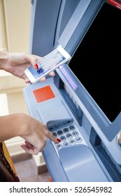 Close Up Of Hand Entering Pin At An ATM. Finger About To Press A Pin Code On A Pad. Security Code On An Automated Teller Machine. Female Arms, ATM - Entering Pin