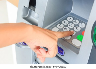 Close Up Of Hand Entering Pin At An ATM. Finger About To Press A Pin Code On A Pad. Security Code On An Automated Teller