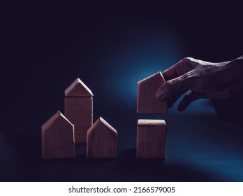 Close up hand establishes a toy wooden house,investment concept. - Shutterstock ID 2166579005