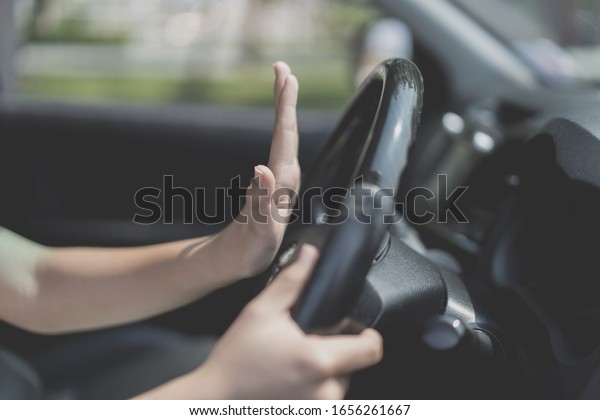 Close\
up hand of female Driver Pressing Horn Car , Feeling Angry and\
hopeless While Driving. concept of Car traffic at rush hour in\
downtown area of the city and people. Car\
pollution