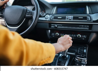 Close up of hand of female driver shifting gear stick before driving car