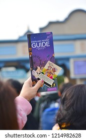 Close Up Hand Of Female Tourist Holding Everland Resort Guide Brochure And Ticket With Blurred Many Tourist Background.Everland Is South Korea's Largest Theme Park.Oct 29,2018 : South Korea.