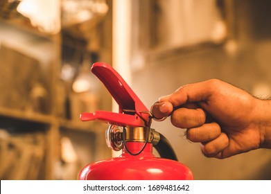 Close up hand Fireman using fire extinguisher fighting. Hand pulling pin of fire extinguisher