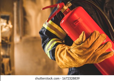 Close up hand Fireman,Firefighter holding the fire extinguisher.