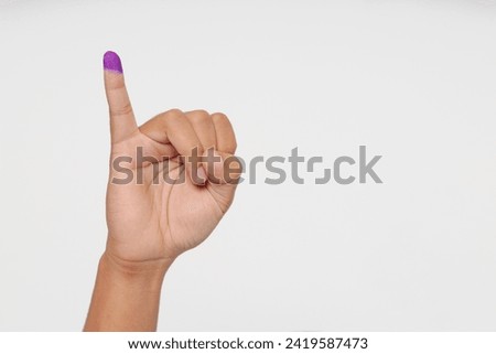 Close up of hand gesture little finger after voting. General elections or Pemilu for the president and government of Indonesia. The finger dipped in purple ink. Isolated image on white background