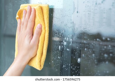 Close Up Hand Glass Cleaner On A Sheet Of Cleaning Glass Window With A Cloth Special Rag Yellow.  Cleaning Germs  Bacteria And Virus.