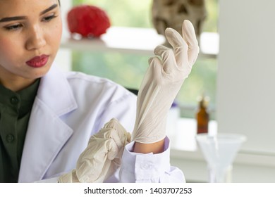 close up a hand glove was pulled down by asian female scientist that was blurred. She had awareness, careful, prevention and safety for healthcare before do scientific experimental in laboratory - Powered by Shutterstock - Get 15% off with code: PIKWIZARD15