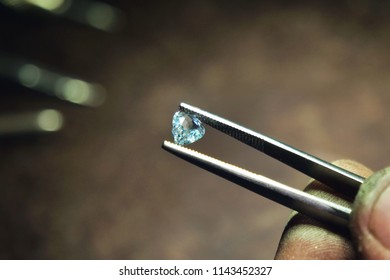 Close up of a hand of a goldsmith who with professional tweezers, checks the diamonds that he will use for the production of handmade luxury jewelery. Concept of: tradition, luxury, jewelry. - Powered by Shutterstock