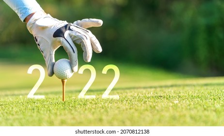 Close Up Hand Golfer Woman Putting Golf Ball For Happy New Year 2022 On The Green Golf For New Healthy.  Copy Space. Healthy And Holiday Concept.