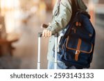 A close up of the hand in green jacket dragging a luggage while walking away in the empty train station or railway station.