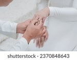 Close up hand groom wear wedding rings to left finger of bride, Muslim wedding, Wedding Poster, invitation card, copy space .