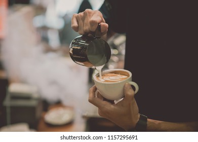 Close Up Hand Guy Is Pouring Coffee Into The Cup.