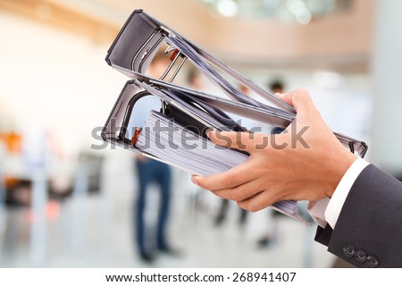 close up of hand holding binder in office