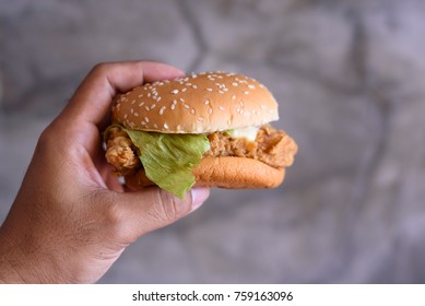 Close up hand holding chicken burger for rush hour time.Fast food concept. - Powered by Shutterstock