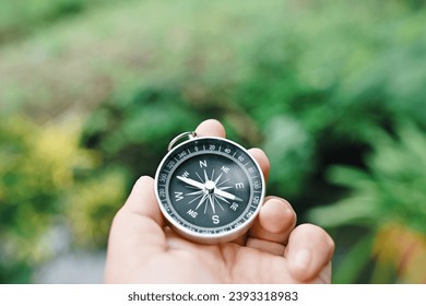 close up hand holding compass with green nature copy space background for text, travel and lifestyle, planning and manage to success business concept - Powered by Shutterstock