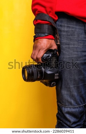 Close up hand holding dslr camera near shank of legs