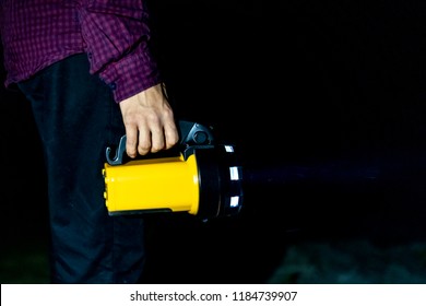 Close Up Hand Holding Electric Torch Flashlight In Dark Nature Forest Outdoor Standing On Sand