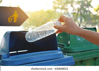 Nahaufnahme der Hand, die leere Flasche in den Müll hält