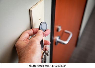 Close up of hand holding key FOB to gain access to an interior office door  - Shutterstock ID 1702103134