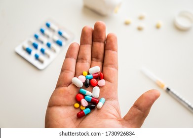 Close up hand holding medicine pills on white table background.