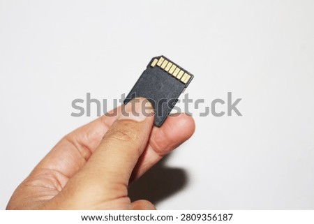 Close Up Hand Holding Memory Card Isolated on White Background for Digital Storage and Technology Use