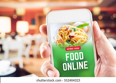 Close Up Hand Holding Mobile With Order Food Online Word On Screen With Blur Restaurant Bokeh Light Background,online Marketing Concept.