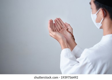 Close Up Hand Holding A Muslim Beads Or Tasbih With On Grey Background, Pray To God In Pandemic Covid-19. Ramadhan Kareem.