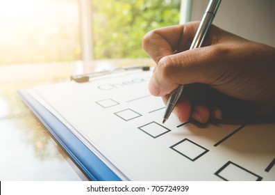 Close- up hand holding pen on check list paper and the format for filling in information in business concept,vintage style and softtone - Shutterstock ID 705724939