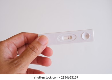 Close Up Hand Holding Pregnancy Test With A Stripe On White Background. Negative Result. 