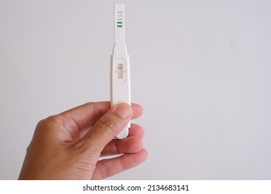 Close Up Hand Holding Pregnancy Test With A Stripe On White Background. Negative Result. 