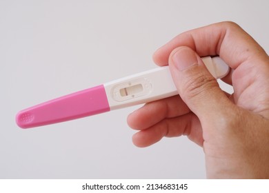 Close Up Hand Holding Pregnancy Test With A Stripe On White Background. Negative Result. 