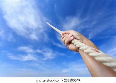 Close Up Hand Holding Rope On Blur Sky Background