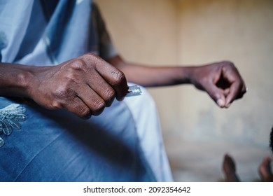 Close up hand holding silver razor blade to symbolize FGM in African poor communities household