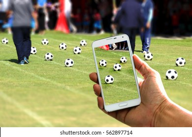 Close up hand holding smartphone taking photo at soccer field  - Powered by Shutterstock