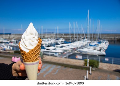 Close Up Of Hand Holding Soft Serve Ice Cream With Ocean Background In Ito City, Shizuoka, Japan