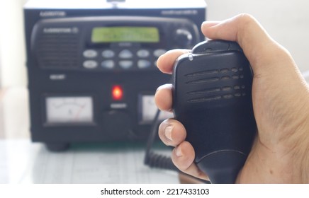 Close Up Of Hand Holding Speaker Radio Transceiver Base Station.