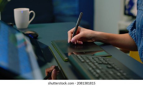 Close up of hand holding stylus on graphic tablet for retouch work. Woman photographer using editing app for pictures retouching at photography studio. Image editor with devices