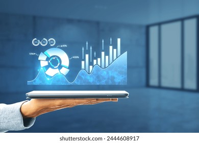 Close up of hand holding tablet with creative digital business pie chart on blurry office interior background. Glowing stock market analysis and big business data analysis - Powered by Shutterstock