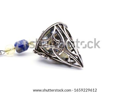 Close up of hand holding and using amethyst crystal pendulum on silver chain fortune telling pendulum in hand on white background. The mysterious concept of the wizard.