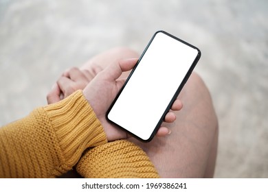 Close up of hand holding, using cell phone with blank screen.