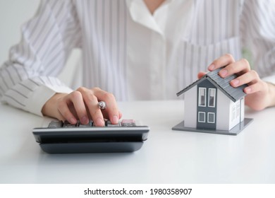 close up hand with house model for real estate check and summary expense of home loan mortgage for refinance plan, insurance or loan real estate. - Shutterstock ID 1980358907