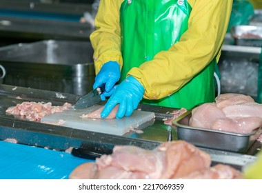 Close Up Hand Of Knife Slice Raw Chicken On Cutting Board In Poultry Factory.