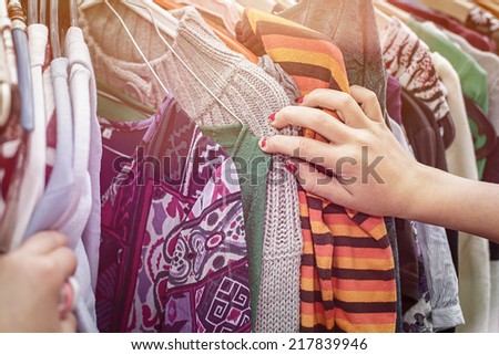 close up of a hand, looking on a flea market for clothes.