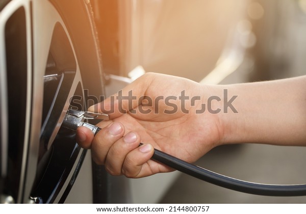 close up hand man car parking a check and\
inflate the tire fill up the air for safe driving on the go.\
Transportation travel vehicle concept.\
